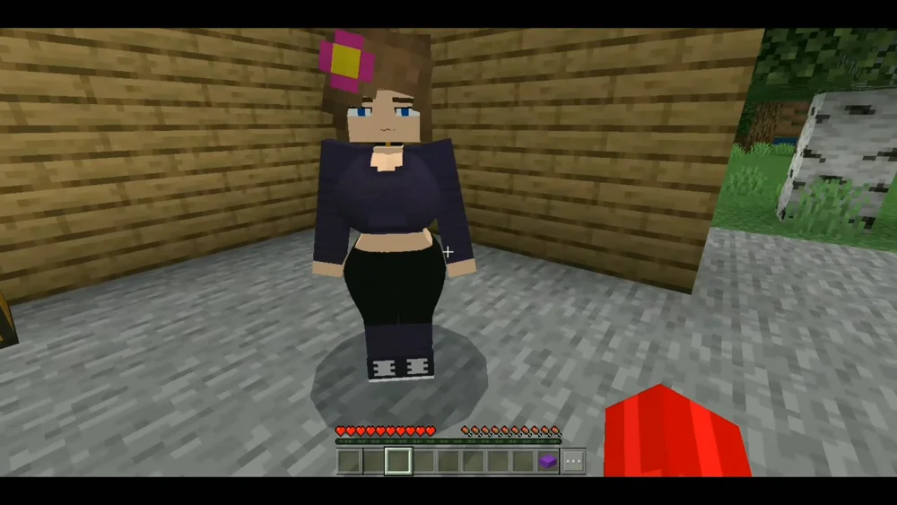 Minecraft Bedrock Edition screenshot showing a female Jenny Mod character near a bed and stone block setup, with a wooden house in the background — used during the mod installation process.